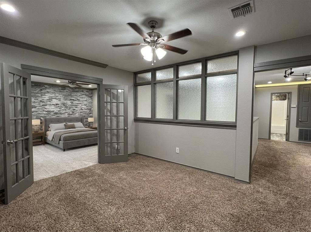 2500 Sierra Drive, McKinney, TX 75071 Double French doors with frosted glass panels open to a carpeted room featuring a stone accent wall