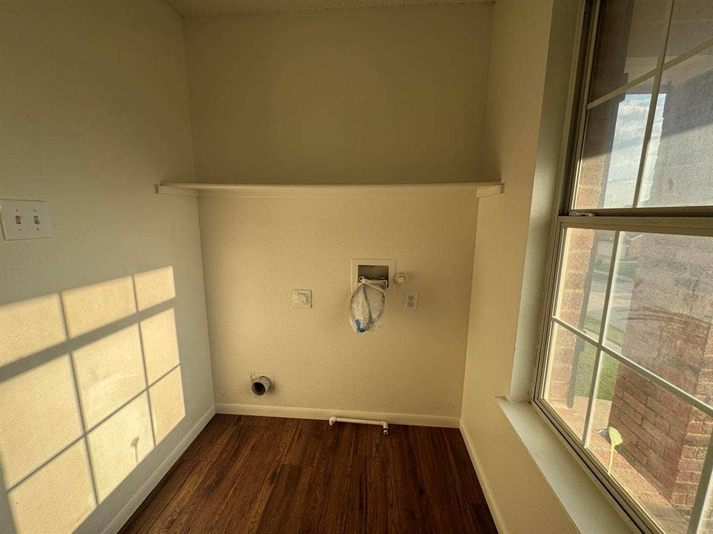 Dedicated utility space featuring wood-finish flooring, a functional window with grid panes, and a convenient upper shelf