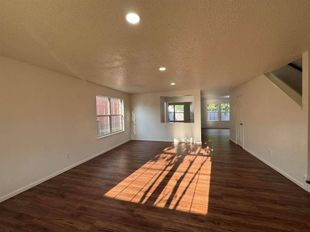 7305 Marsland Lane, Arlington, TX 76001 Spacious room with wood-finish flooring, recessed lighting, and multiple windows with blinds
