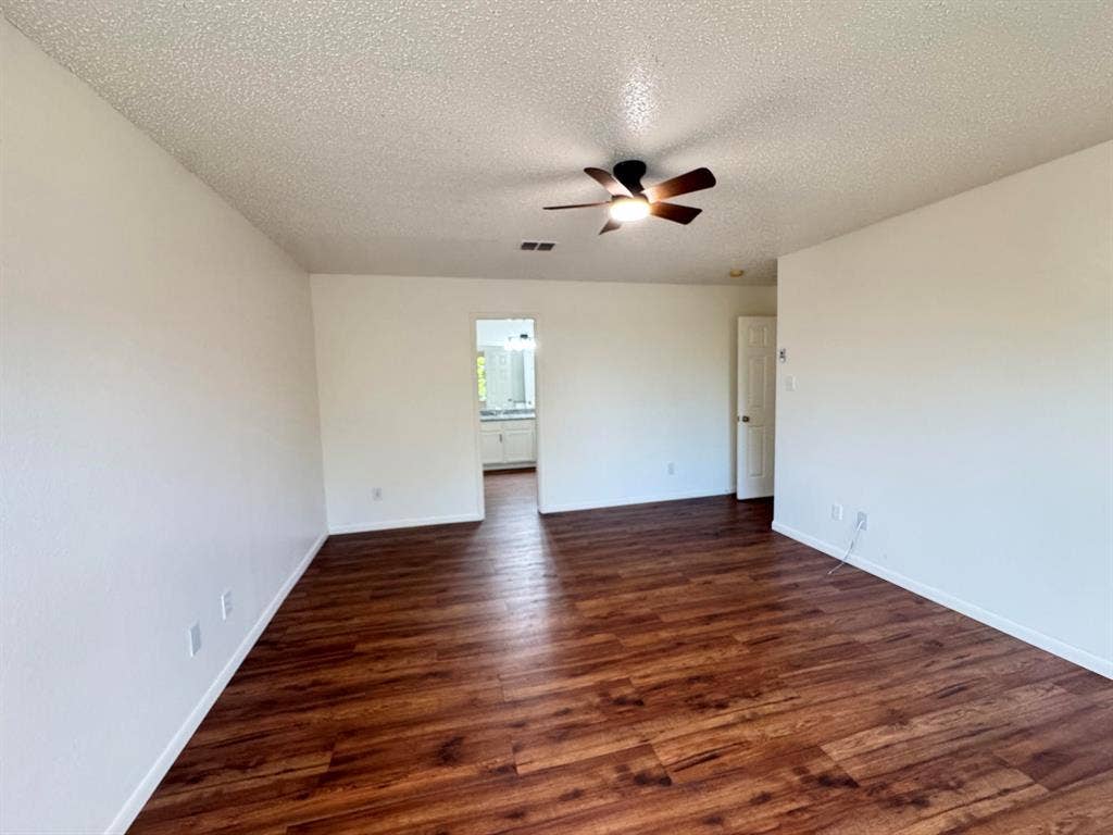 7305 Marsland Lane, Arlington, TX 76001 Spacious room featuring wood-finish flooring, light-colored walls, and a ceiling fan