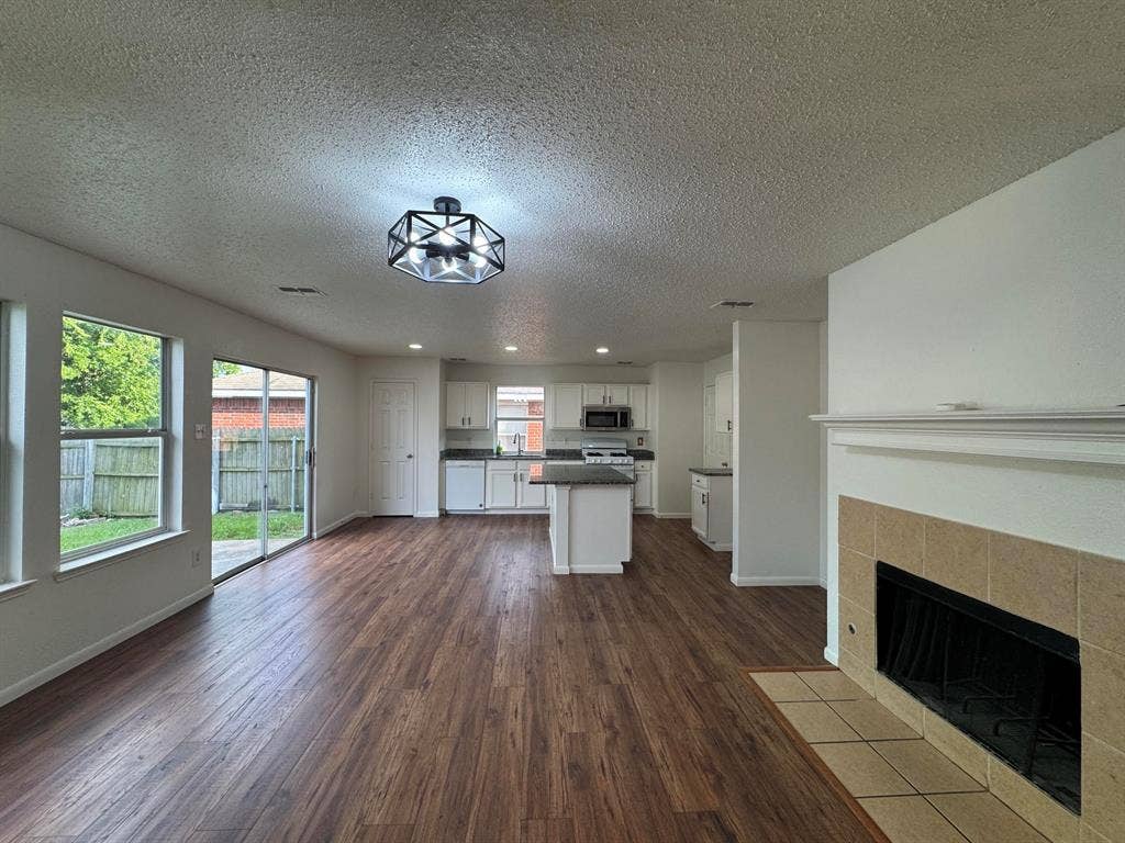 7305 Marsland Lane, Arlington, TX 76001 Spacious interior featuring wood-finish flooring, a contemporary ceiling light fixture, and white walls