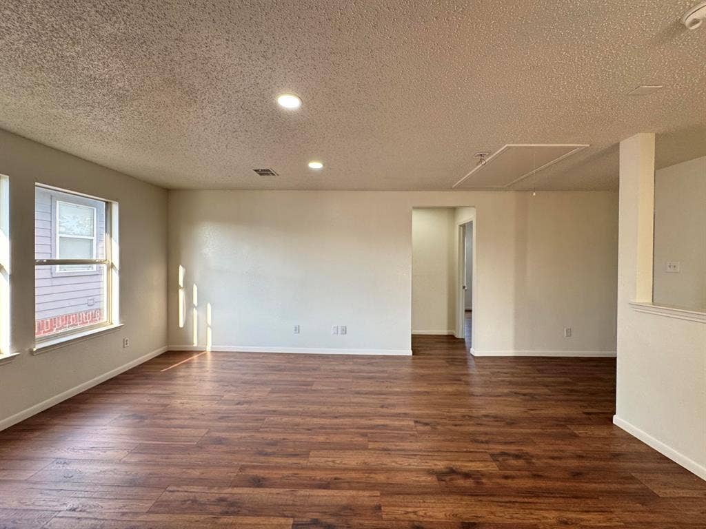 7305 Marsland Lane, Arlington, TX 76001 Spacious room featuring wood-finish flooring, recessed lighting, multiple windows, and light-toned walls