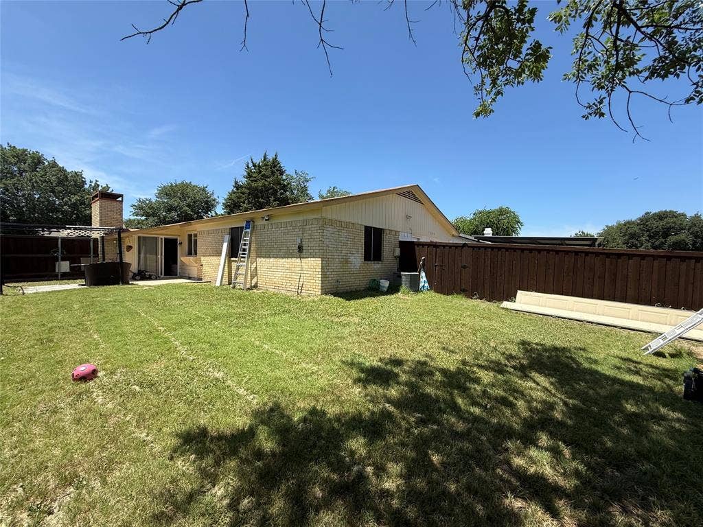 2809 Royalty Drive, Garland, TX 75044 Expansive backyard featuring a privacy fence, brick exterior, and a built-in outdoor structure