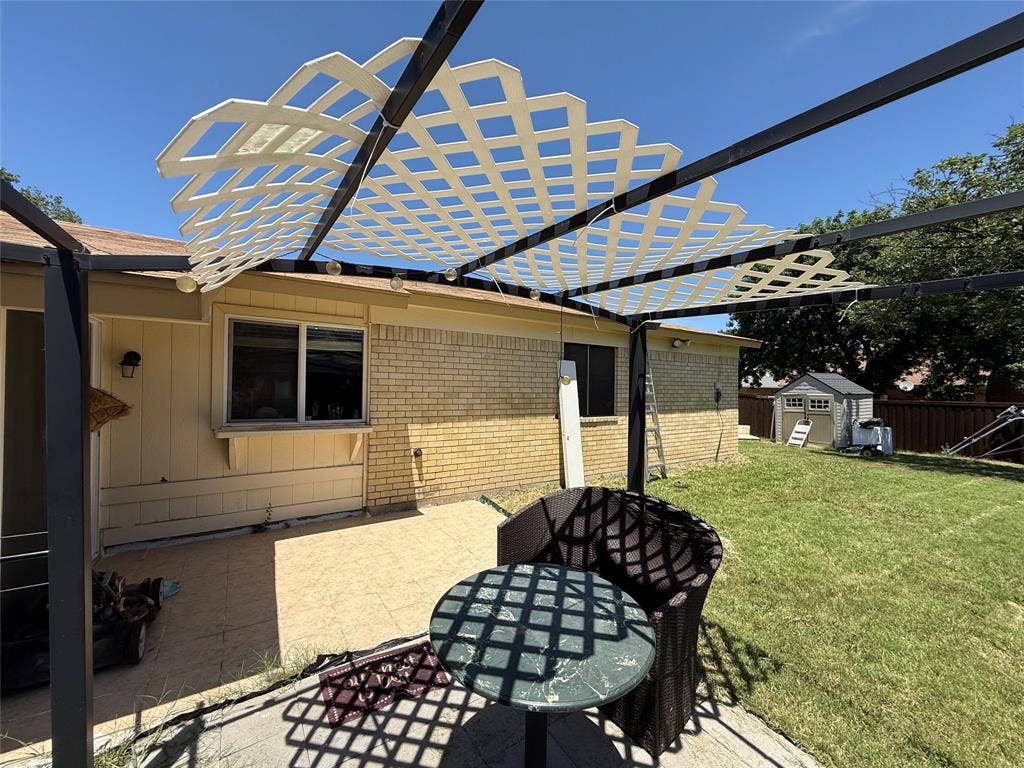 2809 Royalty Drive, Garland, TX 75044 Outdoor patio with a lattice pergola, brick and siding exterior, and a grassy yard