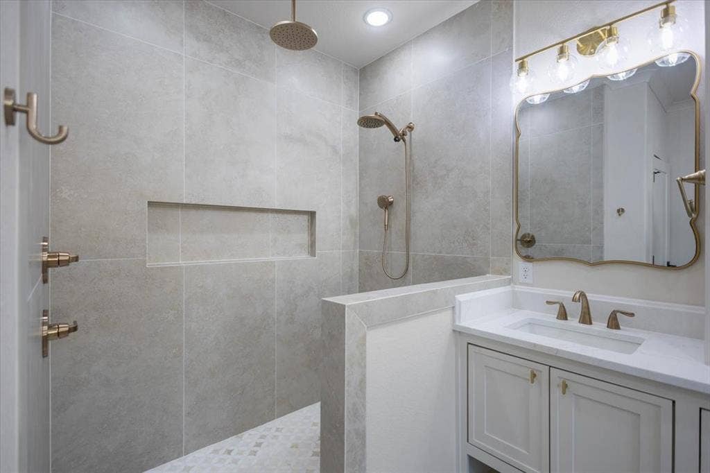 Walk-in shower with a rain shower head, handheld shower, and recessed niche