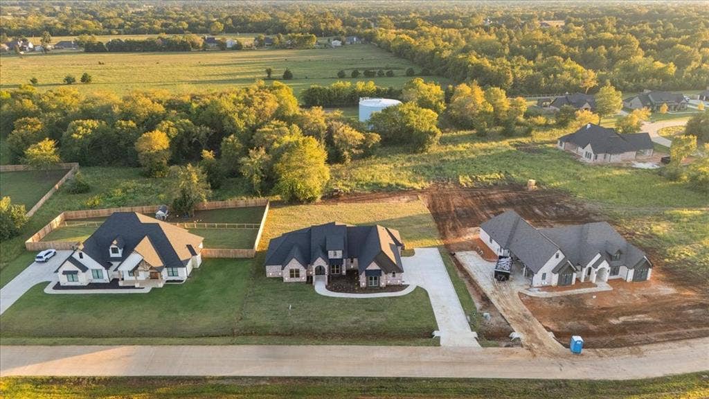 Pitched rooflines, concrete driveways, and expansive green spaces with mature trees