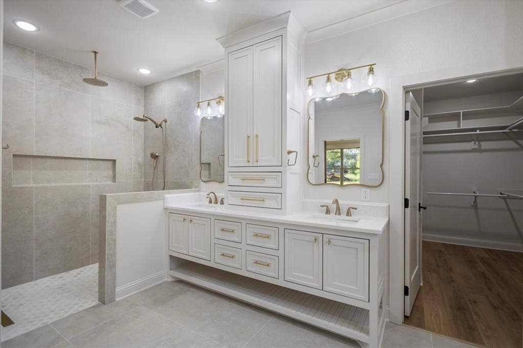 Dual vanity with white cabinetry and gold-toned hardware