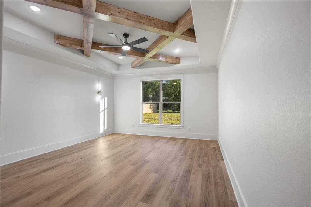 Tray ceiling with wood-finish beams, recessed lighting, and a ceiling fan