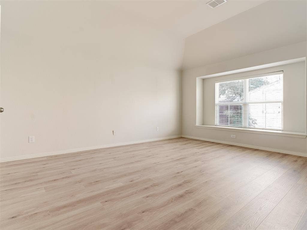 Vaulted ceilings, wood-finish flooring, and a recessed bay window