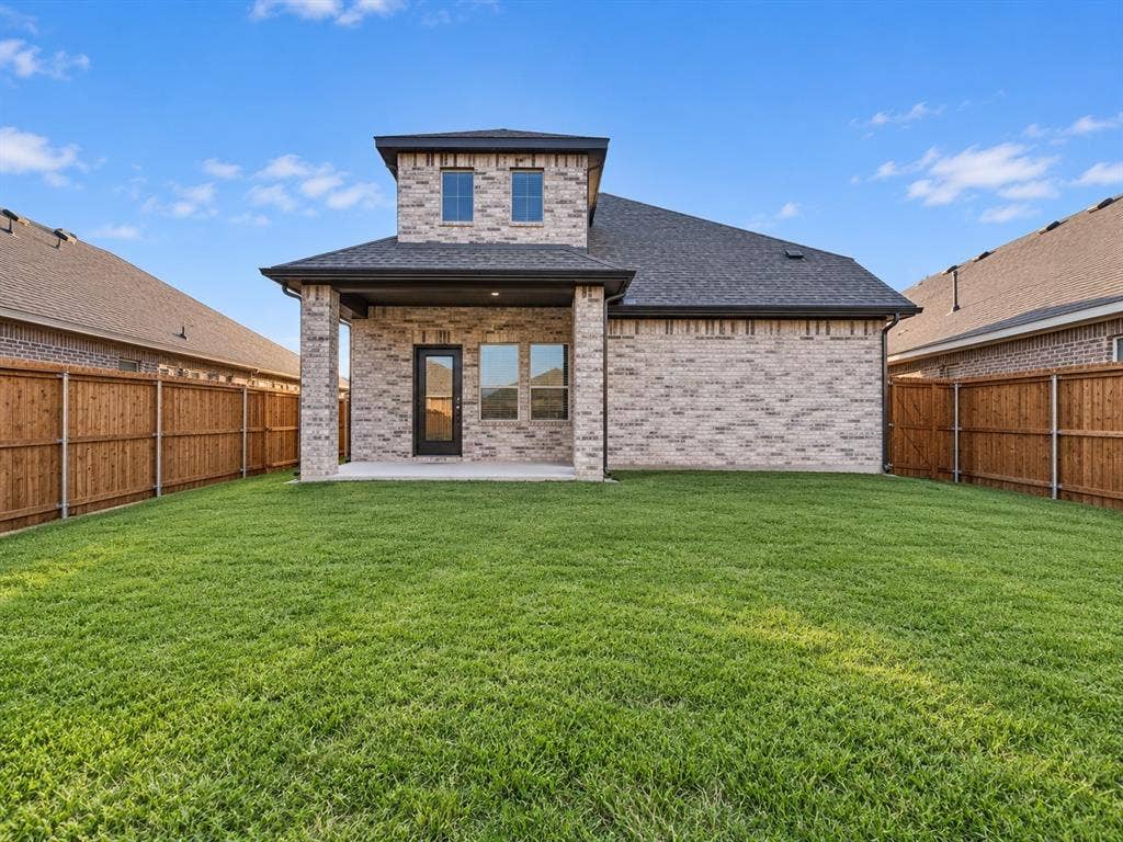 5204 Golden Trout Drive, Princeton, TX 75071 Expansive backyard featuring a manicured lawn, full privacy fencing, and a covered patio