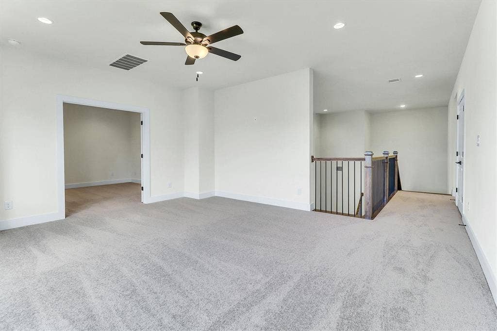 115 Cottonwood Court, Murphy, TX 75094 Recessed lighting, ceiling fan, neutral wall paint, light-colored carpeting, and a wood and metal staircase railing