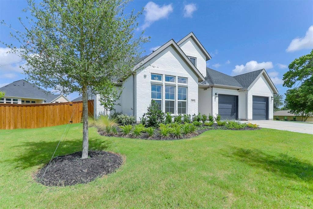 115 Cottonwood Court, Murphy, TX 75094 White brick exterior with a dark shingle roof, featuring multiple gables and a prominent front window arrangement
