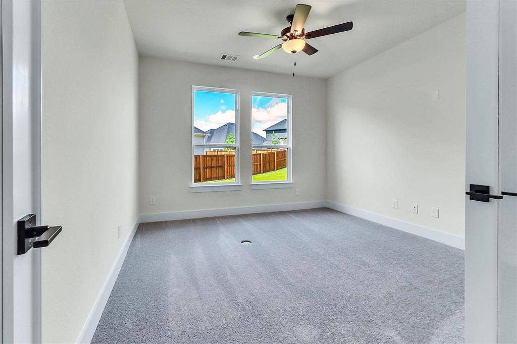 115 Cottonwood Court, Murphy, TX 75094 Carpeted room featuring two windows, a ceiling fan with integrated lighting, and a neutral color palette