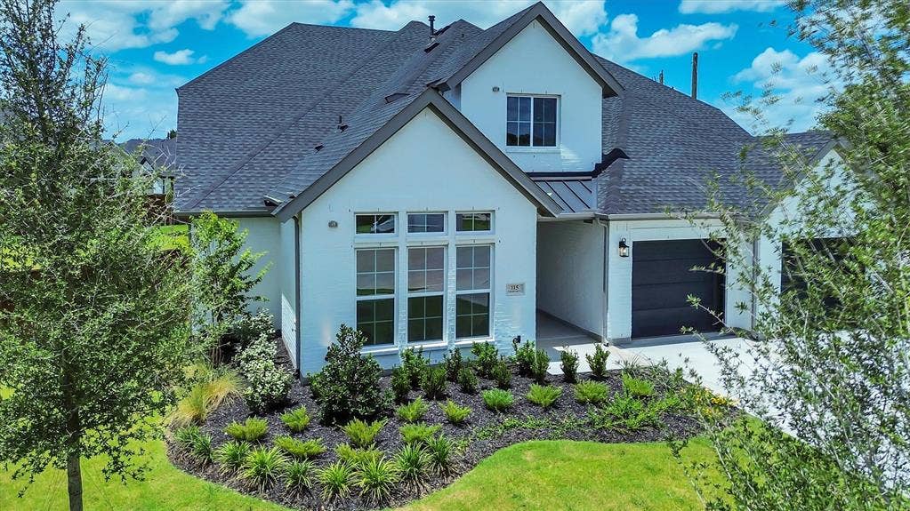 115 Cottonwood Court, Murphy, TX 75094 White exterior with dark gray accents, a two-car garage, and landscaped front yard