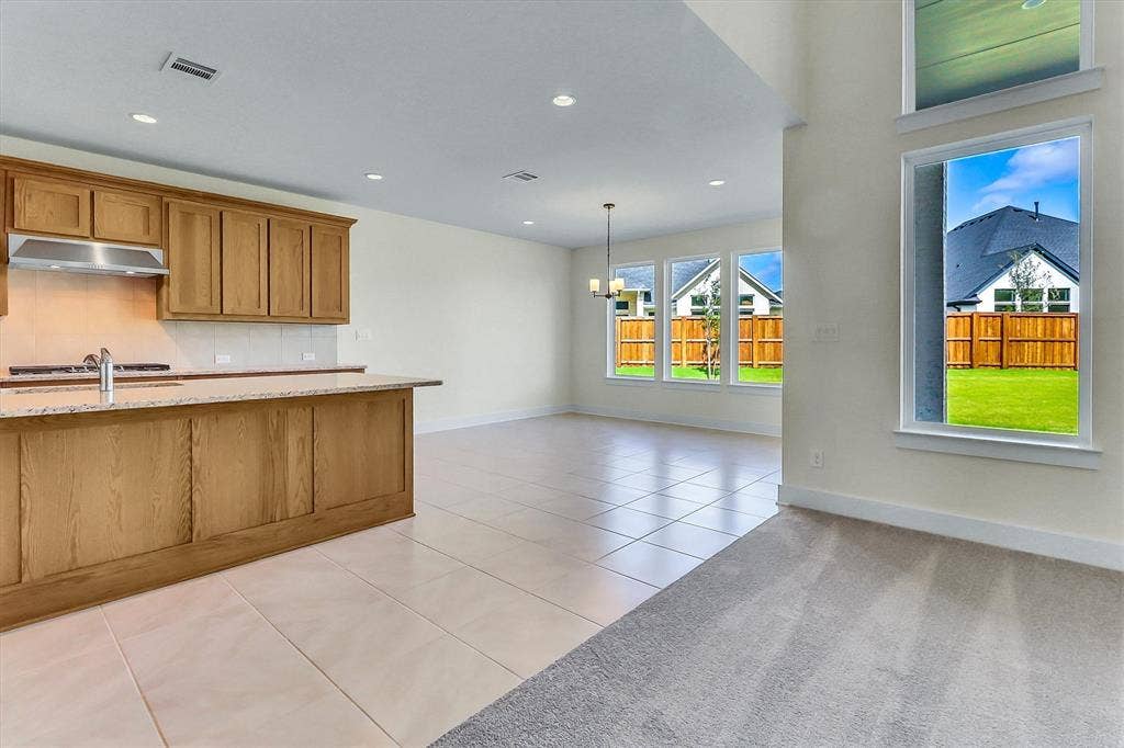 115 Cottonwood Court, Murphy, TX 75094 Kitchen island with granite countertop and stainless steel sink