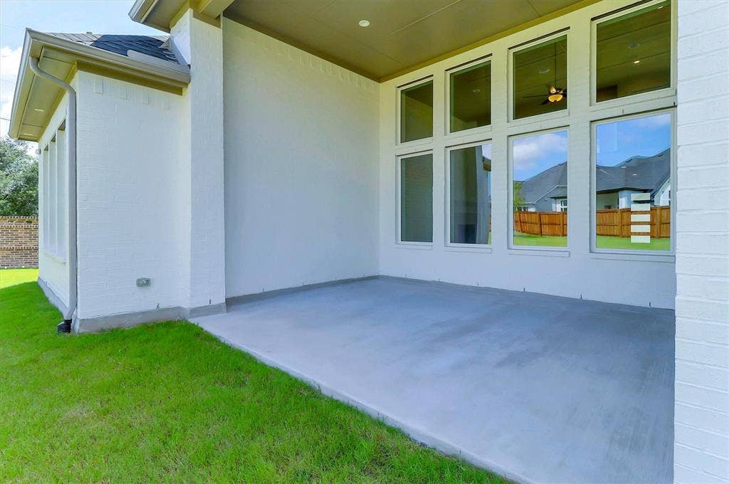 115 Cottonwood Court, Murphy, TX 75094 Covered outdoor patio with a concrete surface, white brick exterior, and multi-pane windows