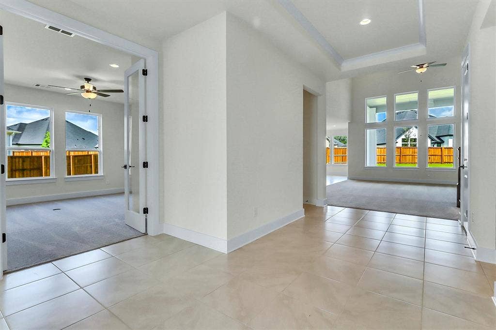 115 Cottonwood Court, Murphy, TX 75094 Tile flooring, tray ceiling, recessed lighting, ceiling fan, and large windows