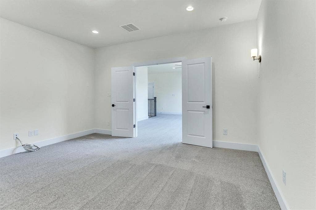 115 Cottonwood Court, Murphy, TX 75094 Light gray carpet, recessed ceiling lighting, wall-mounted sconce, and white paneled double doors