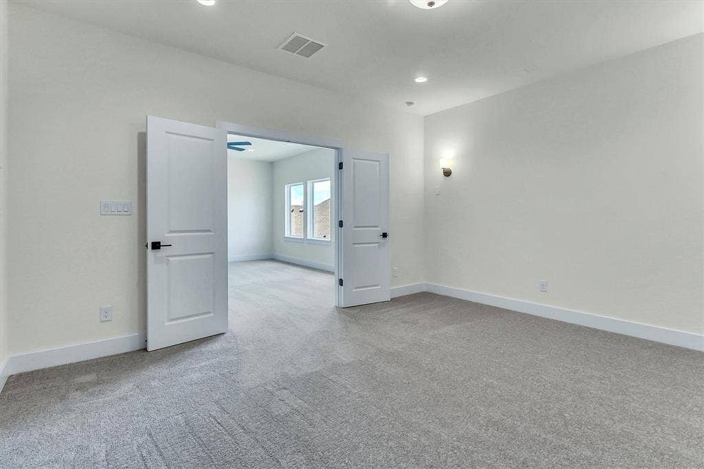 115 Cottonwood Court, Murphy, TX 75094 Neutral-toned carpeting, recessed lighting, and wall-mounted sconce