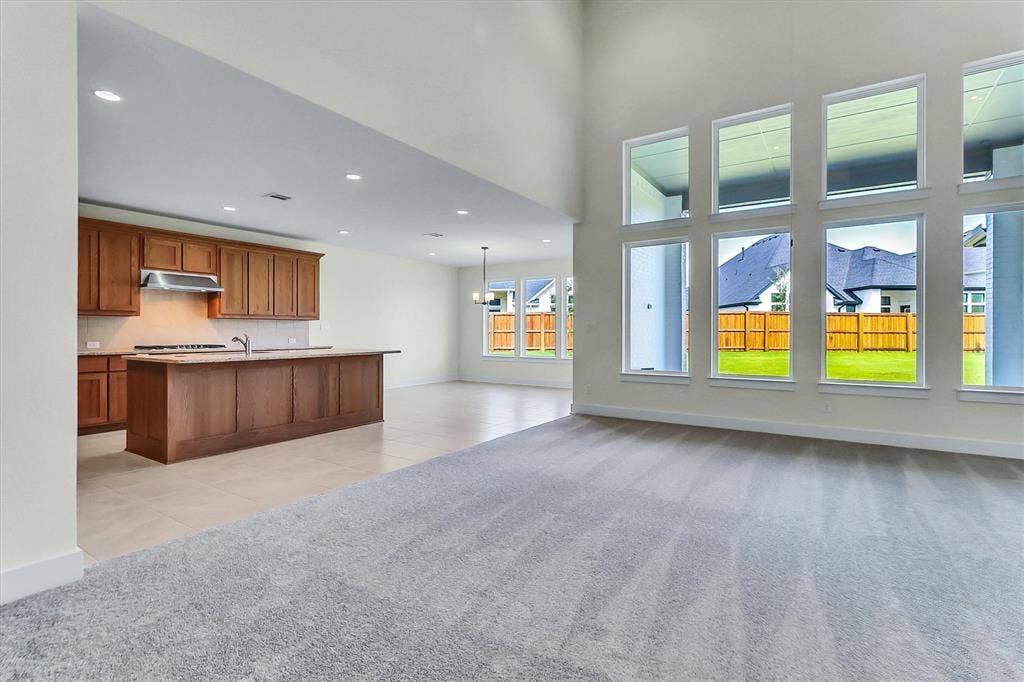 115 Cottonwood Court, Murphy, TX 75094 Open-concept living area with high ceilings, recessed lighting, and expansive windows