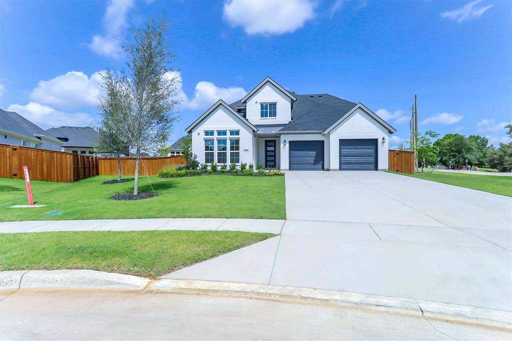 115 Cottonwood Court, Murphy, TX 75094 White exterior with dark roof, two-car garage, manicured lawn, and concrete driveway