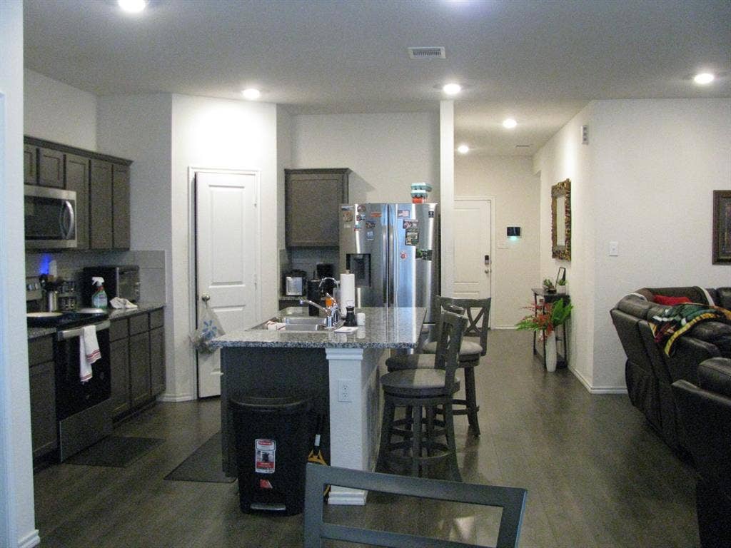 1322 Bushel Drive, Royse City, TX 75189 Spacious kitchen includes stainless steel appliances, granite countertops, and an island with a breakfast bar.