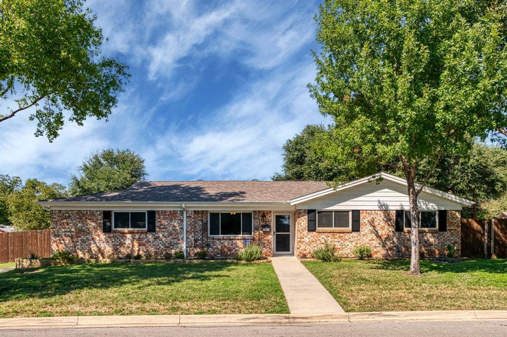 Brick exterior with white siding accents and dark window shutters