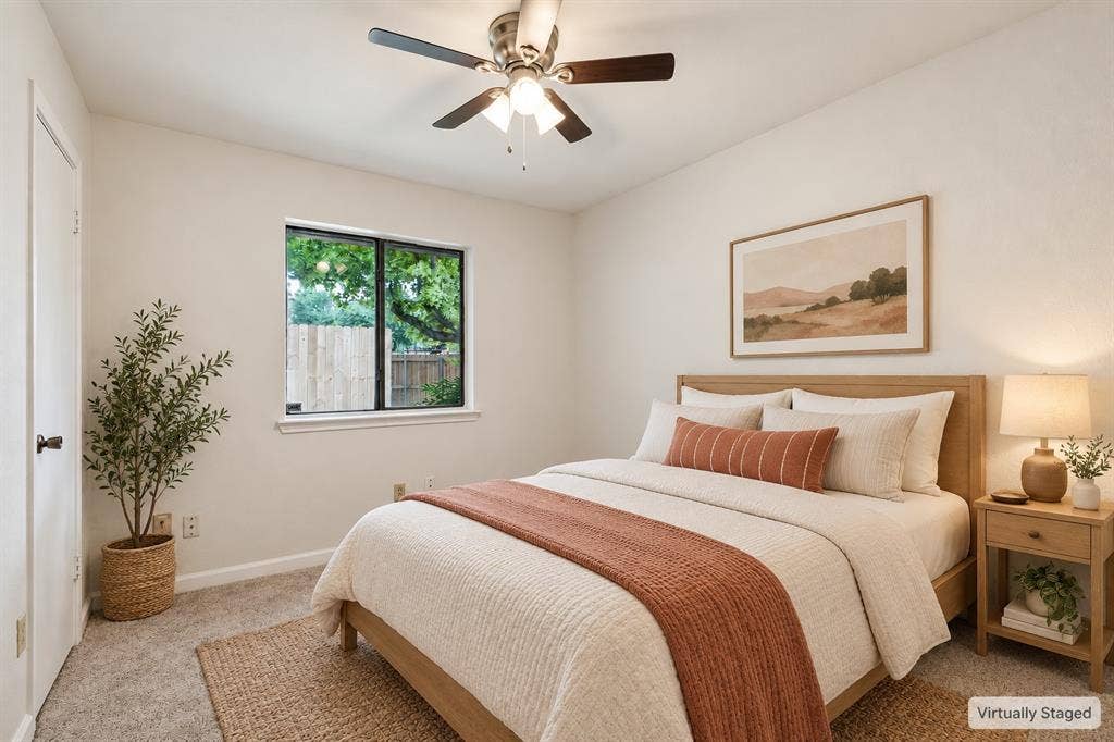 Carpeted flooring, ceiling fan with integrated lighting, and a single window