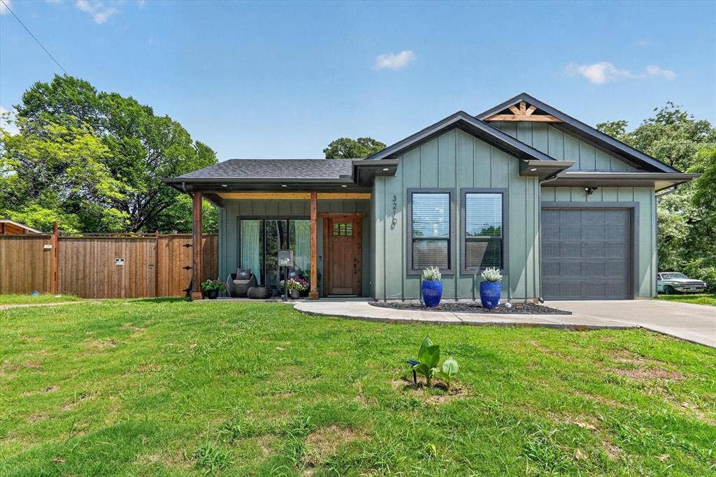 3210 Carpenter Avenue, Dallas, TX 75215 Modern exterior featuring board and batten siding, a covered front porch, and a wood privacy fence