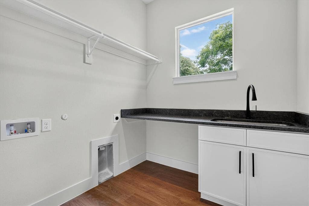 3210 Carpenter Avenue, Dallas, TX 75215 Built-in cabinetry with dark hardware, dark countertop with an integrated sink, and wood-finish flooring
