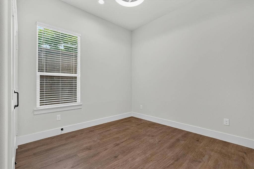 3210 Carpenter Avenue, Dallas, TX 75215 Wood-finish flooring, white walls, recessed lighting, and a window with blinds