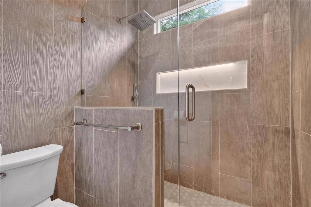 3210 Carpenter Avenue, Dallas, TX 75215 Walk-in shower with clear glass enclosure and overhead rainfall showerhead