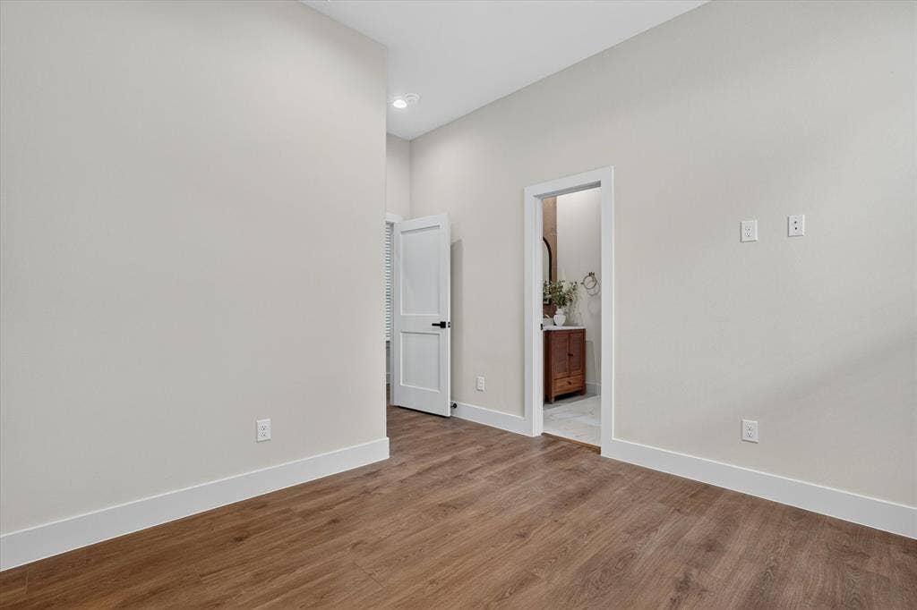 3210 Carpenter Avenue, Dallas, TX 75215 Wood-finish flooring, white trim, recessed lighting, and a white interior door with black hardware