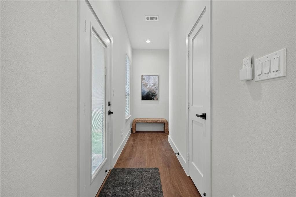 3210 Carpenter Avenue, Dallas, TX 75215 Wood-finish flooring, recessed lighting, and a modern white door with clear glass