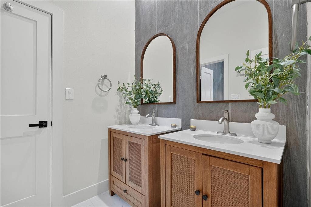 3210 Carpenter Avenue, Dallas, TX 75215 Dual wood-finish vanities with woven cane door panels, white countertops, and integrated sinks
