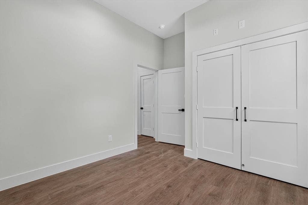 3210 Carpenter Avenue, Dallas, TX 75215 Wood-finish flooring, white flat-panel doors with matte black hardware, and crisp white trim