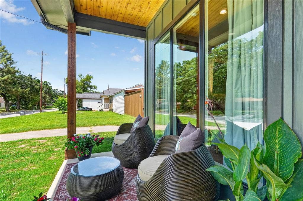 3210 Carpenter Avenue, Dallas, TX 75215 Covered porch with wood ceiling and support posts, featuring a large glass panel door and siding exterior