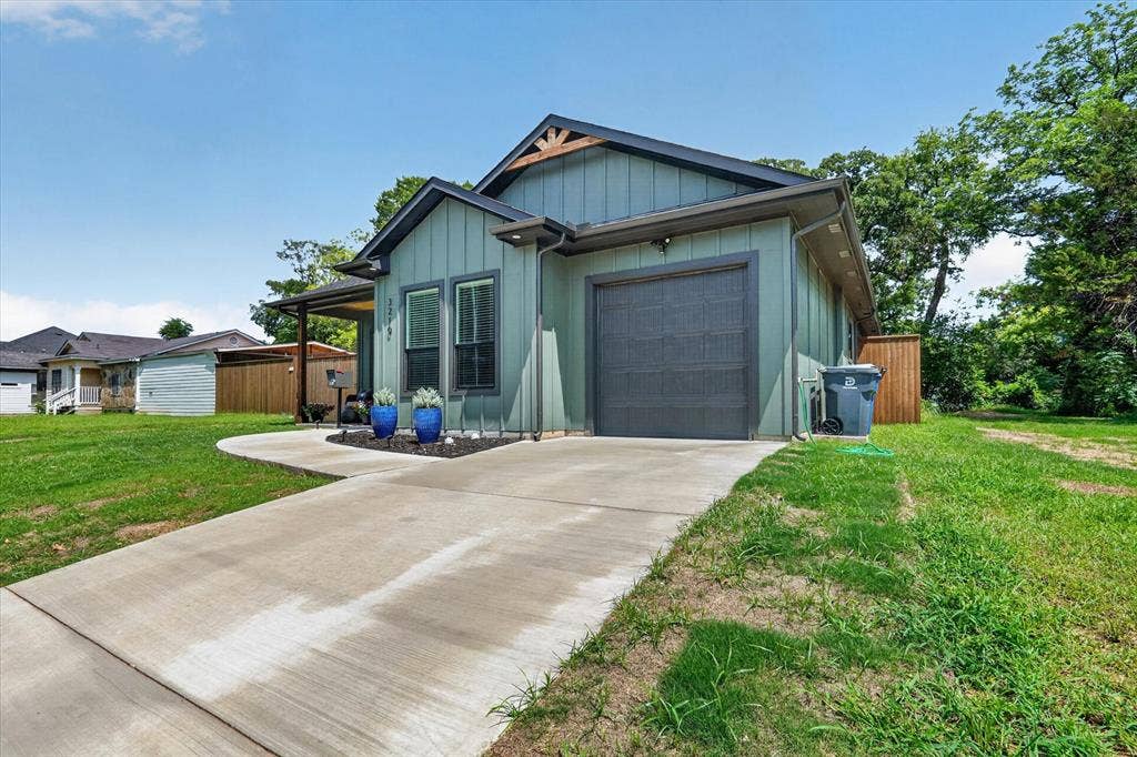 3210 Carpenter Avenue, Dallas, TX 75215 Contemporary exterior with board and batten siding, attached garage, covered entryway, and a concrete driveway