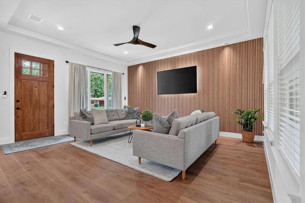 3210 Carpenter Avenue, Dallas, TX 75215 Wood-finish flooring, recessed lighting, ceiling fan, and a wood-paneled accent wall with integrated backlighting