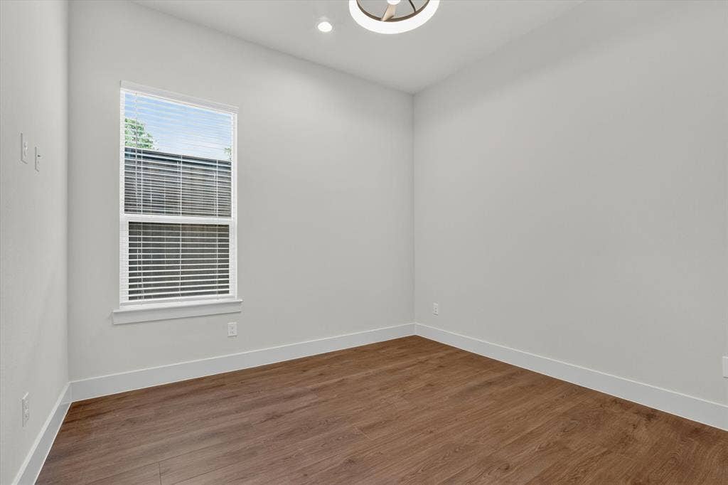 3210 Carpenter Avenue, Dallas, TX 75215 Wood-finish flooring, white trim, single window with blinds, recessed lighting, and a contemporary ceiling fixture
