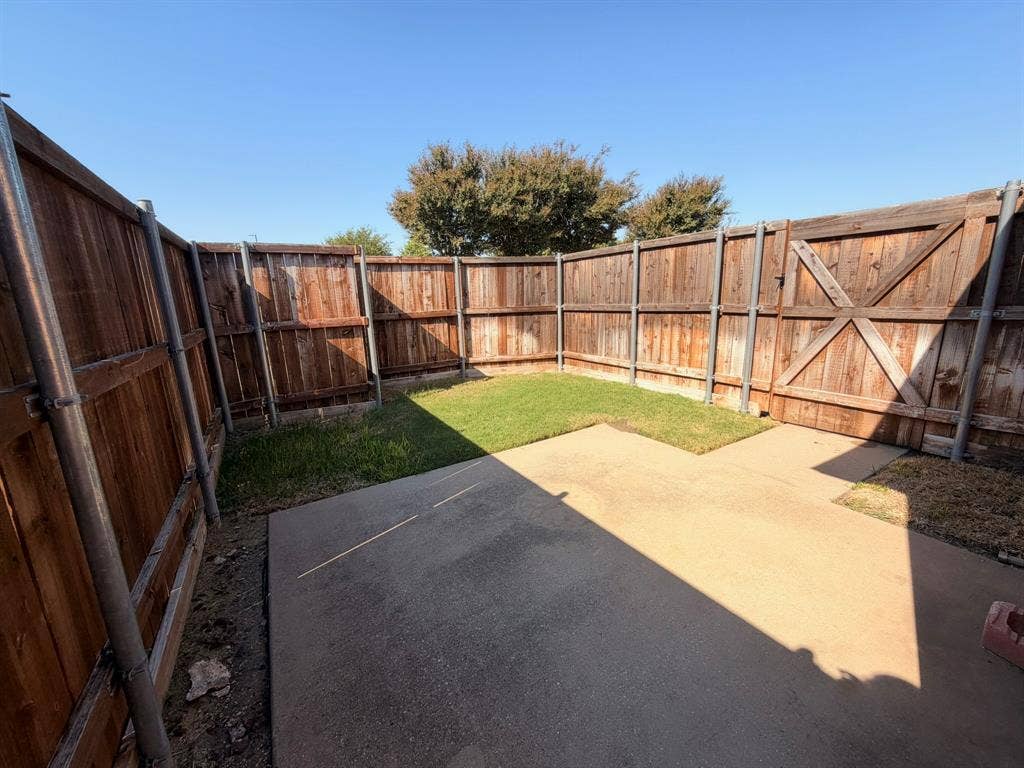 5016 Rushden Road, McKinney, TX 75070 Fenced outdoor space featuring a concrete patio, grassy area, and wood panel fencing