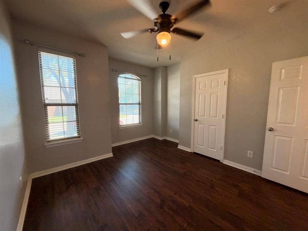 5016 Rushden Road, McKinney, TX 75070 Wood-finish flooring throughout, two panel doors, two windows with blinds, and a ceiling fan with integrated lighting