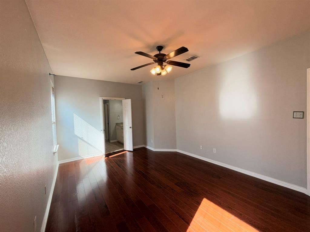 5016 Rushden Road, McKinney, TX 75070 Rich wood-finish flooring, ceiling fan with integrated lighting, and neutral wall tones