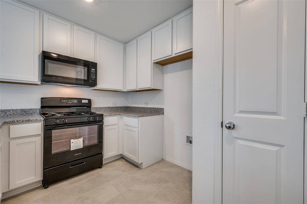 3700 Bluebird Lane, McKinney, TX 75071 Kitchen featuring black appliances, white cabinets, and light tile floors