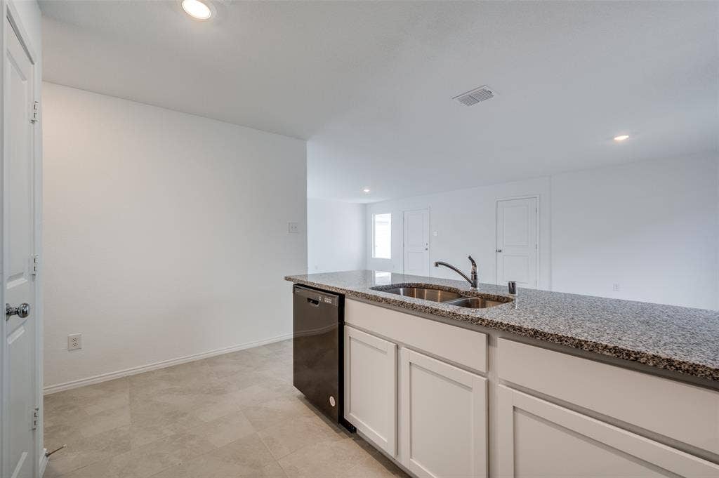 3700 Bluebird Lane, McKinney, TX 75071 Kitchen with white cabinets, light stone counters, dishwasher, sink, and light tile floors