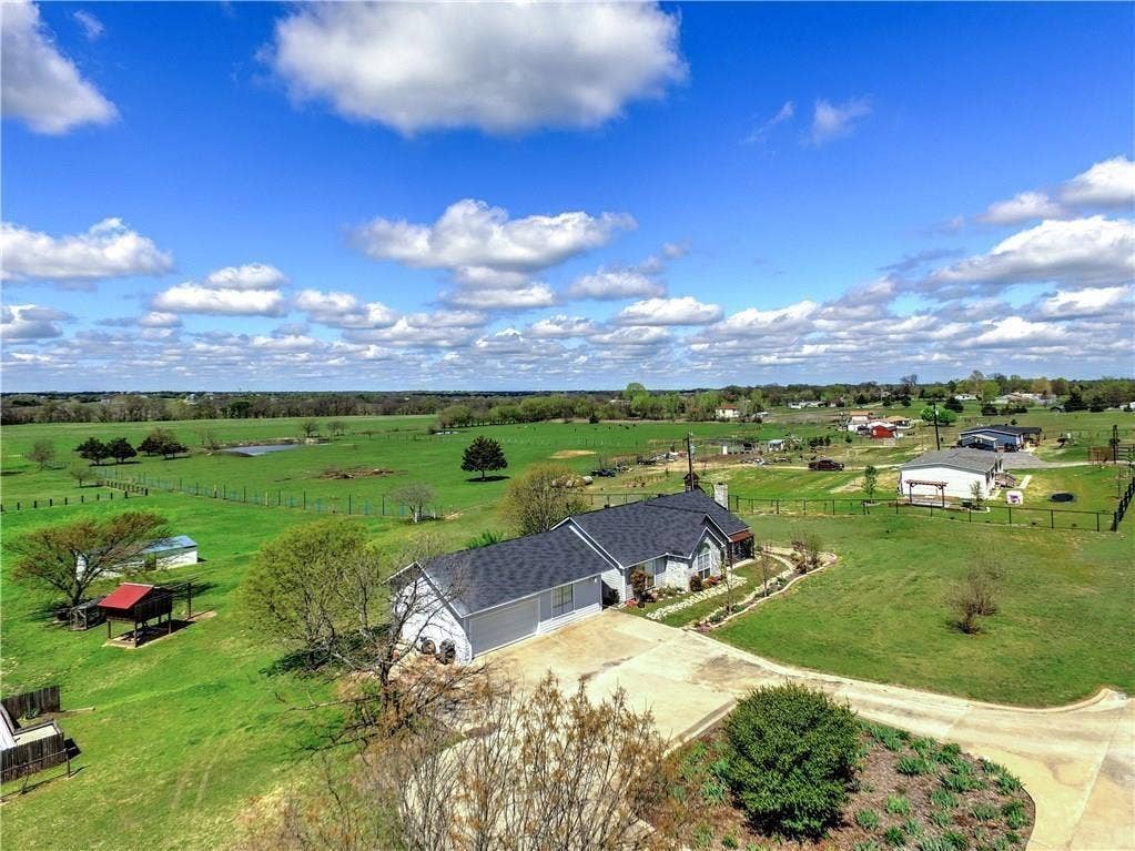 12875 Westover Lane, Anna, TX 75409 Spacious property with a large, gabled roofline, attached garage, concrete driveway, and expansive green lawns