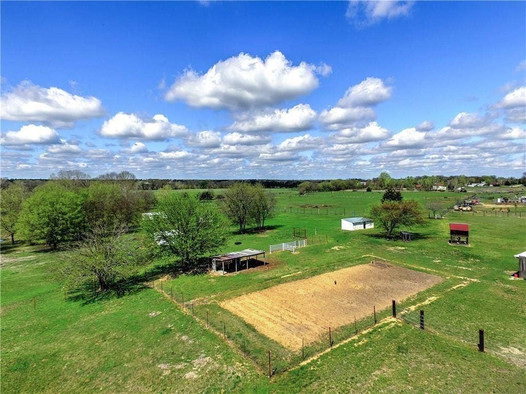 12875 Westover Lane, Anna, TX 75409 Expansive green acreage featuring mature trees, a fenced paddock, and multiple outbuildings