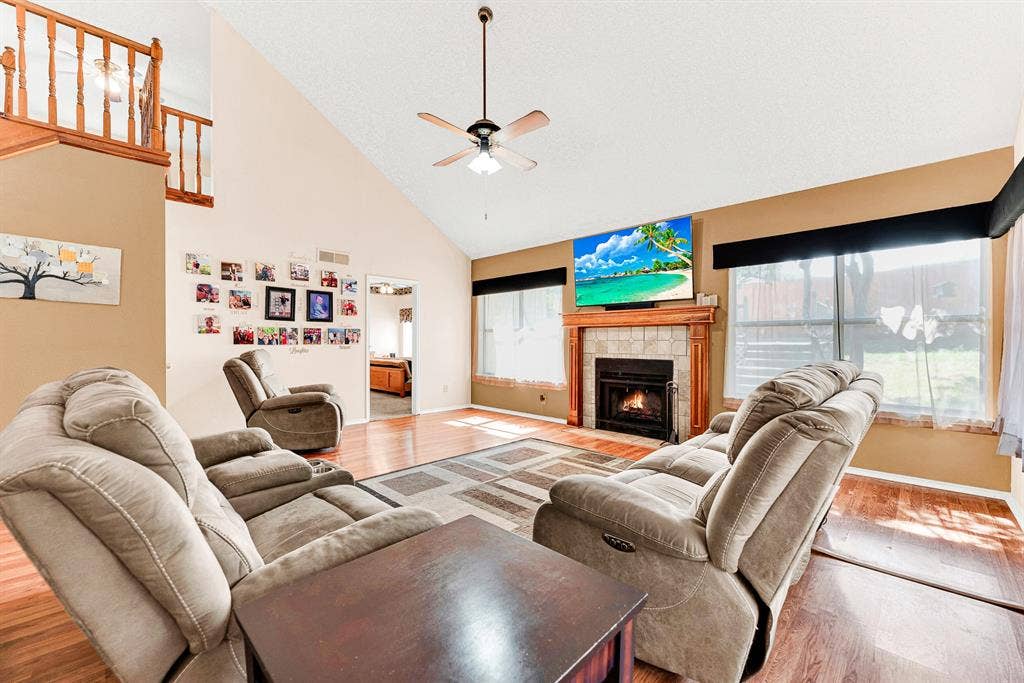A classic fireplace mantel acts as the heart of the room, anchored beneath soaring angled ceilings that draw light across every surface. You can easily picture winding down here on cool autumn evenings with a good book and the soft glow of a fire.
