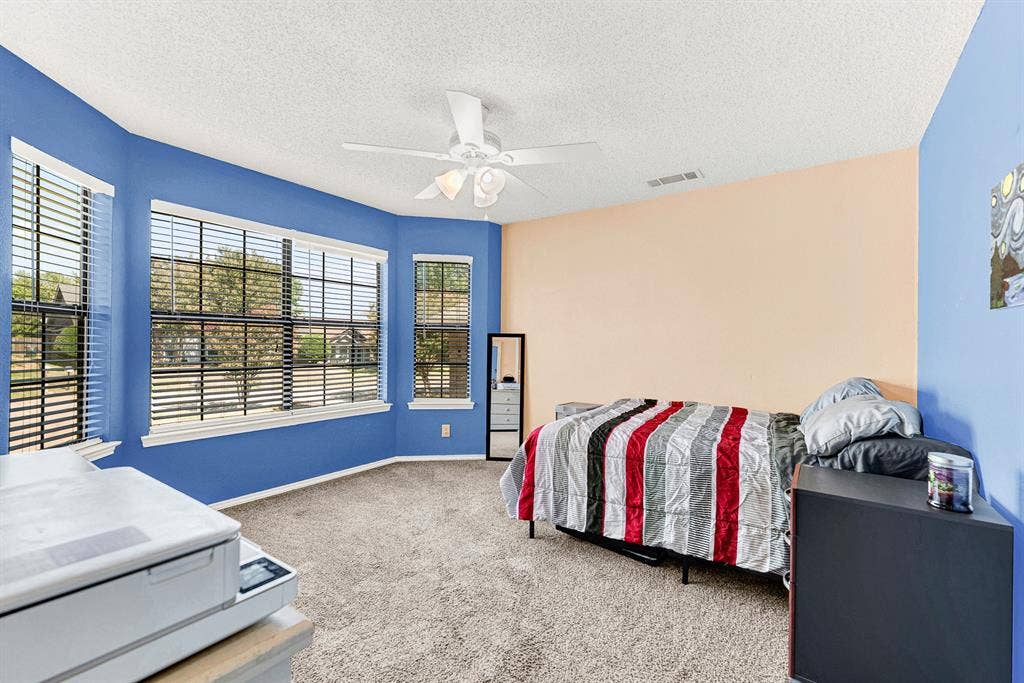 A beautiful bay window arrangement fills this spacious bedroom with gentle morning light, creating an inviting, sunlit retreat. You can easily envision setting up a cozy reading chair by the glass to enjoy quiet weekend afternoons.