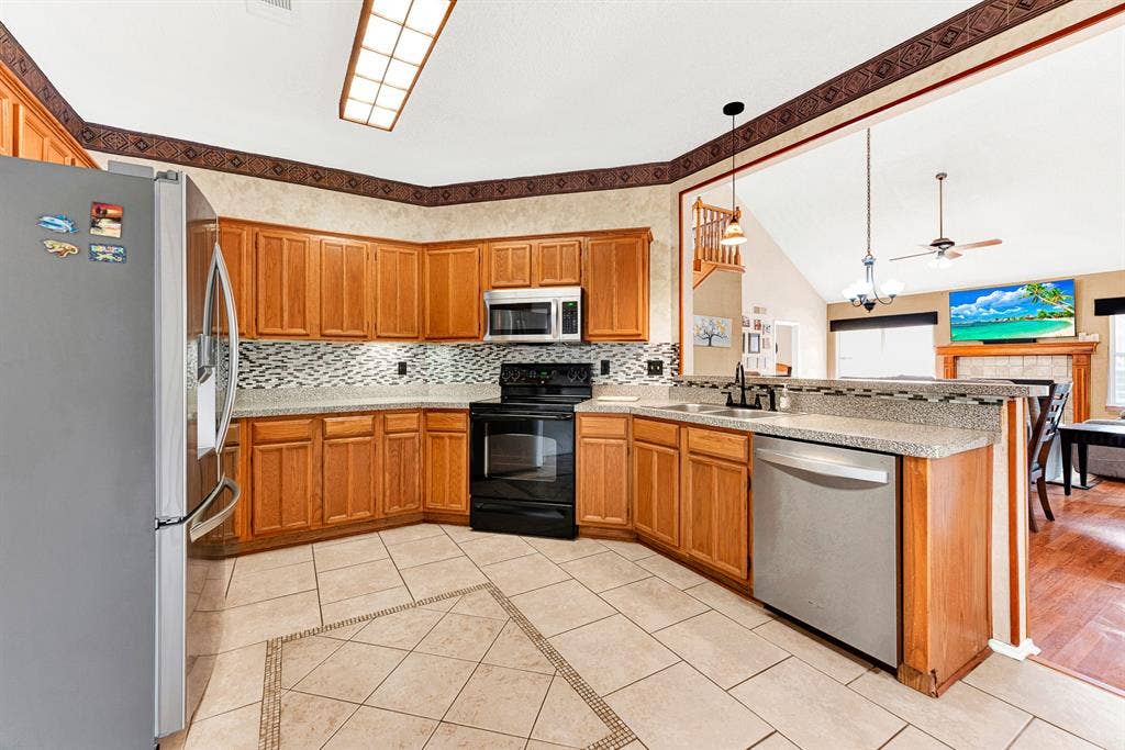 A wide interior pass-through window framed by warm wood cabinetry creates an airy sightline directly into the main living area. You can cook up your favorite recipes without missing a single moment of game night or conversation.